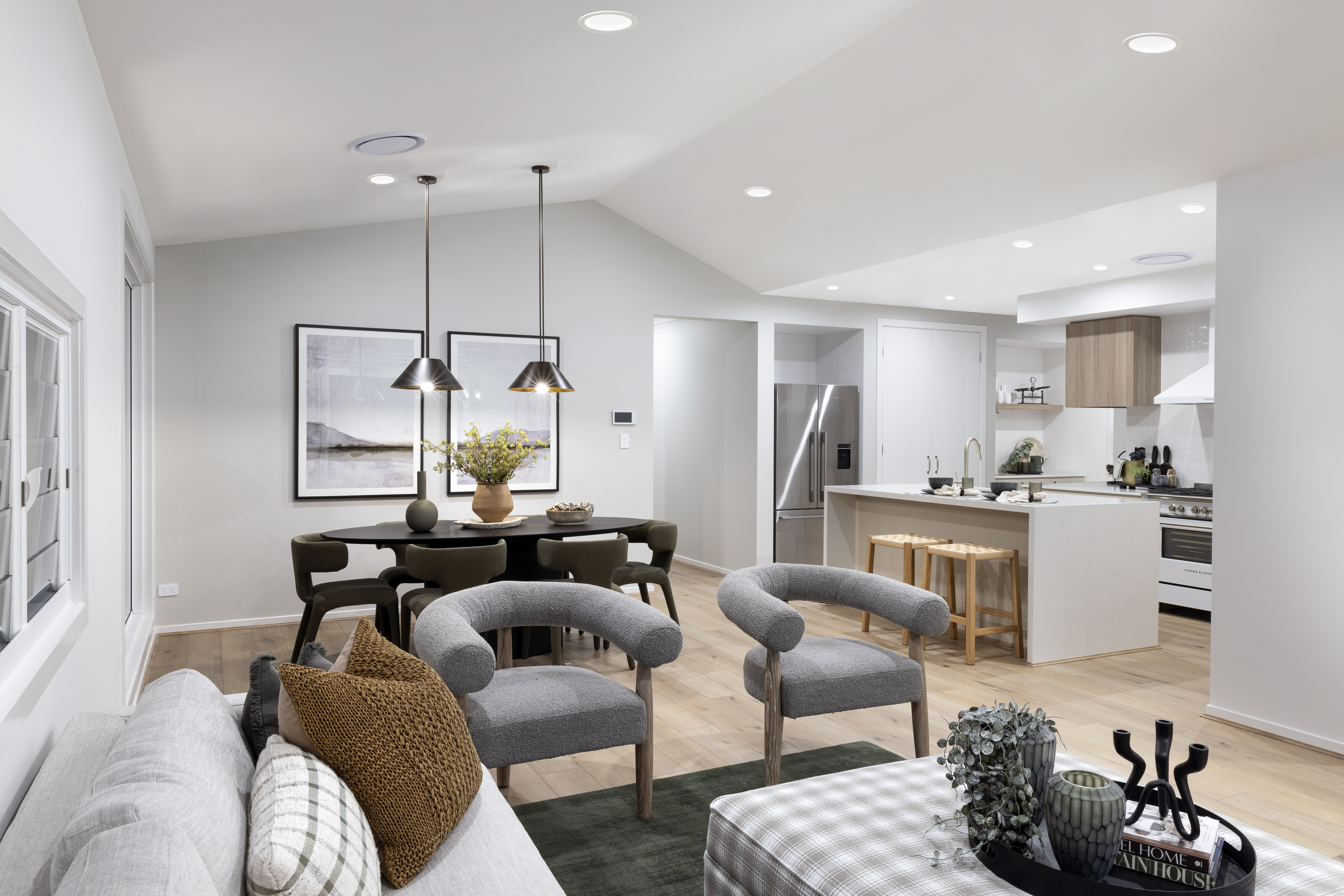 Open plan living, dining and kitchen area with raked ceiling.